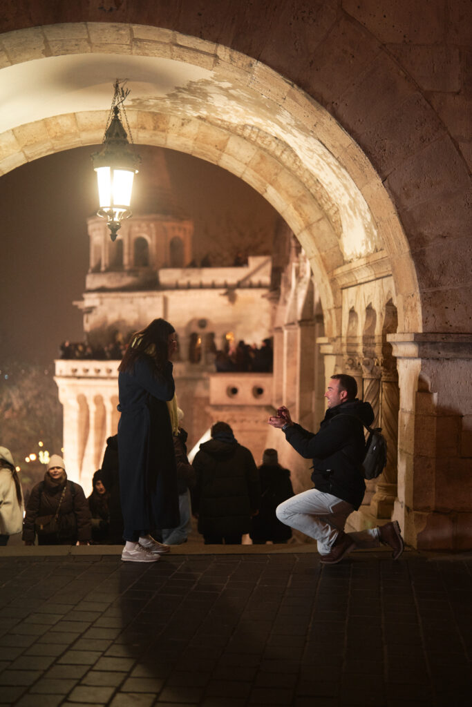Budapest proposal at Fisherman’s Bastion captured at night, featuring a surprise marriage proposal under historic arches